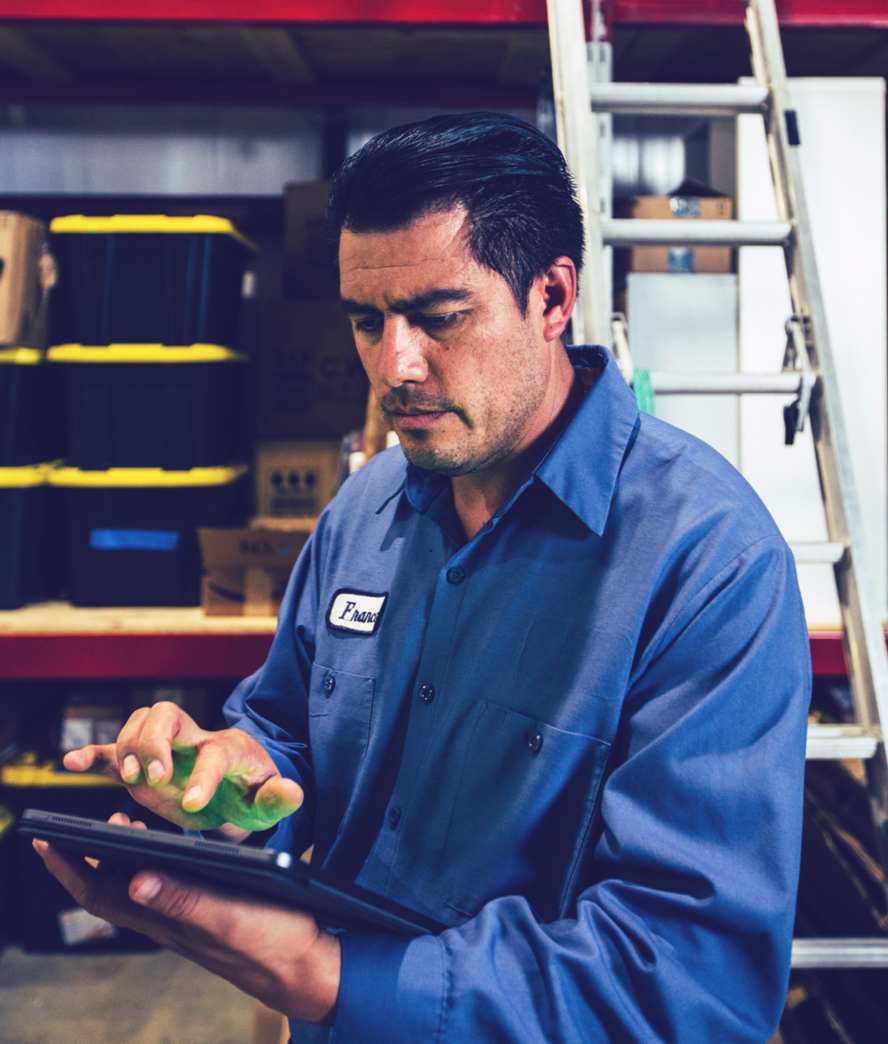 Man working inside warehouse on tablet